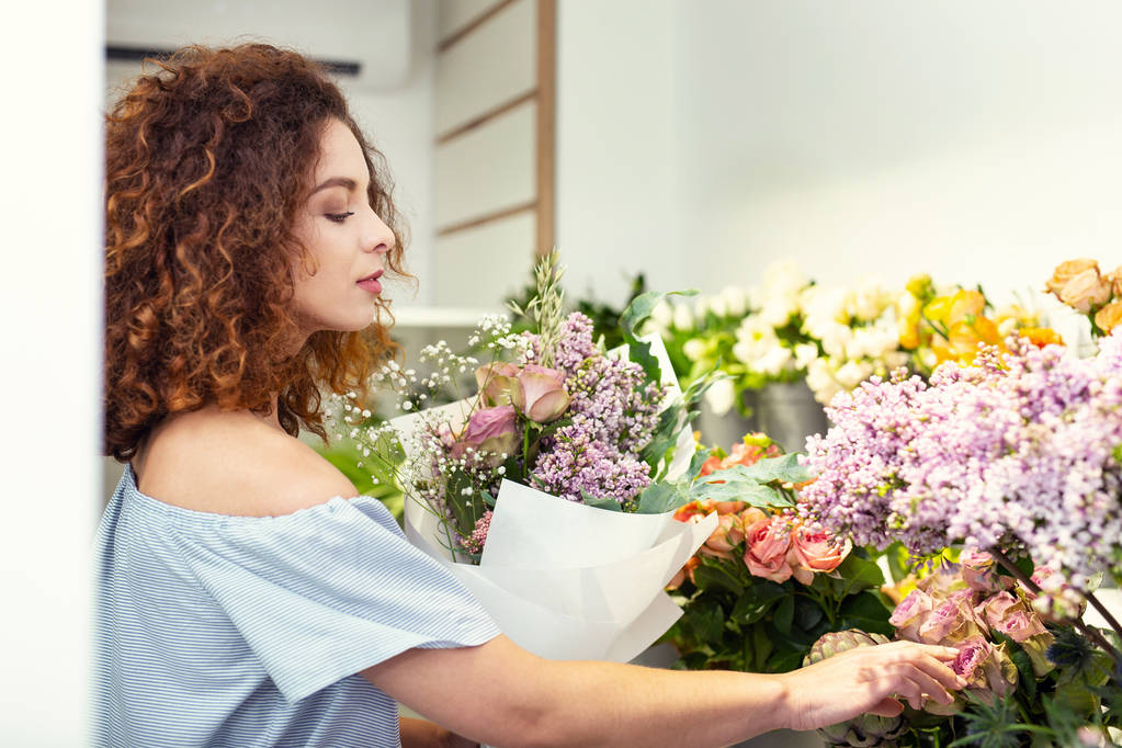 Slimme mooie vrouw in de bloemenwinkel - Foto, afbeelding
