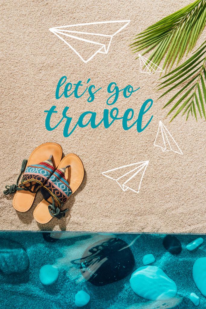 Blick von oben auf stylische Flip Flops am Sandstrand mit "lets go travel" -Inspektion  - Foto, Bild