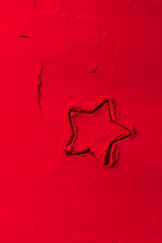vista elevada de la forma del cortador de galletas en forma de estrella sobre polvo rojo
  - Foto, Imagen