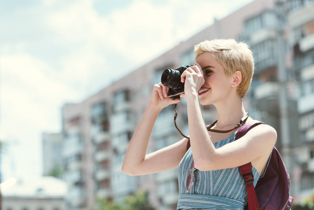 young woman taking photo on camera in city - Photo, Image