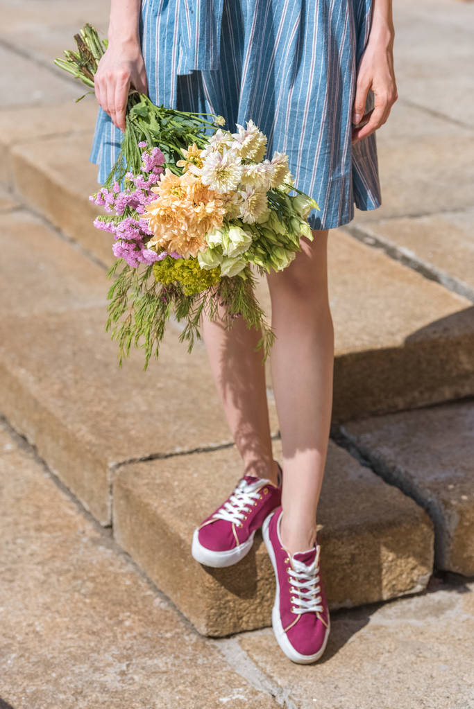 przycięte widzenia dziewczynka gospodarstwa bukiet kwiatów - Zdjęcie, obraz