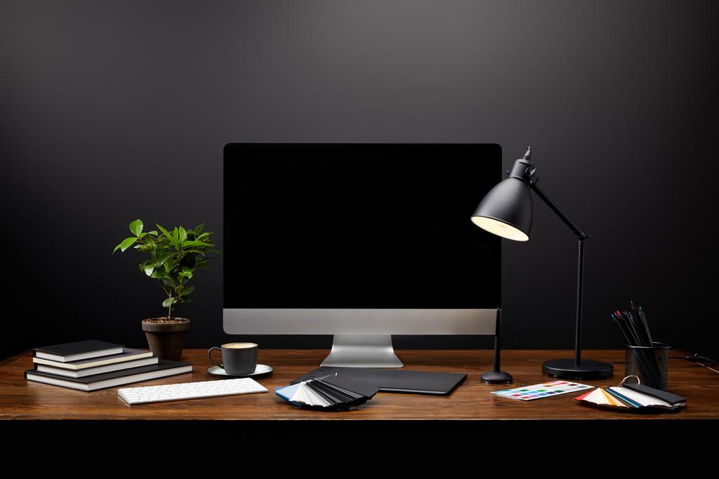 Close-up van grafisch ontwerper werkplek met grafisch tablet, lege computerscherm, notebooks en pallet op houten tafelblad - Foto, afbeelding