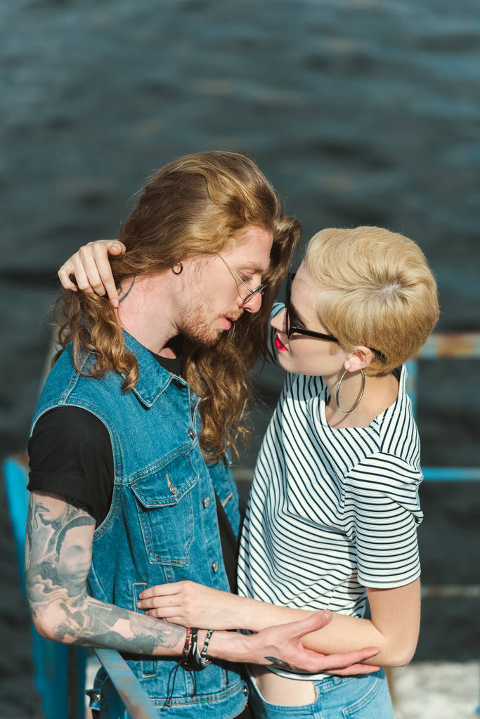 высокий угол зрения бойфренда с татуировками и стильной подруги, собирающейся поцеловаться на мосту
 - Фото, изображение