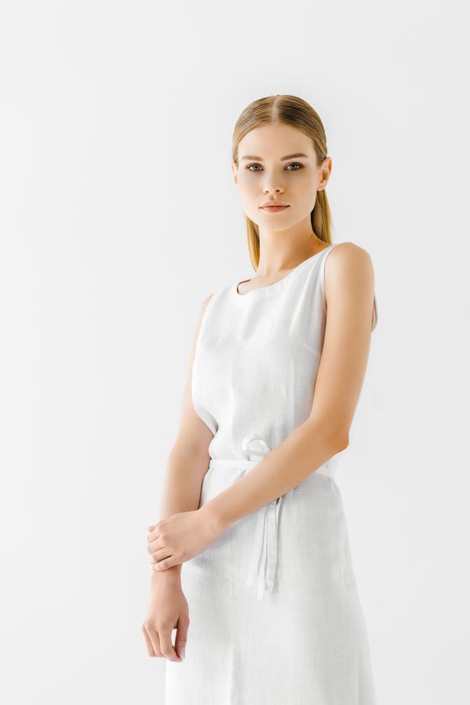 リネンの白いドレスに孤立した灰色の背景をポーズで若い魅力的な女性  - 写真・画像