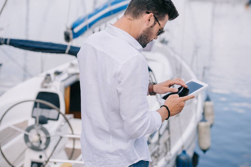 férfi napszemüveg segítségével digitális tabletta, yacht közelében hátulnézete - Fotó, kép