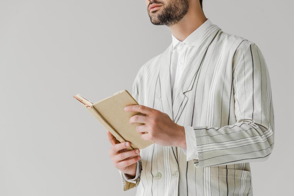 plan recadré de jeune homme en veste rayée tenant livre isolé sur blanc
 - Photo, image