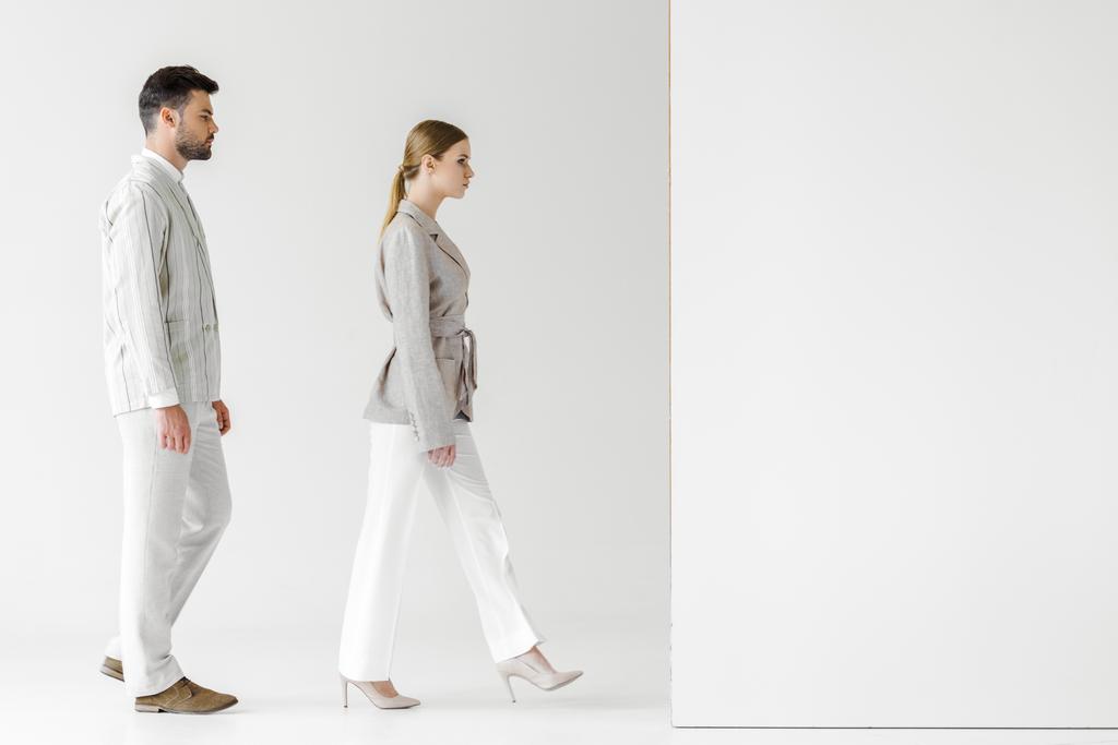 young male and female models in vintage clothes walking at white wall - Photo, Image
