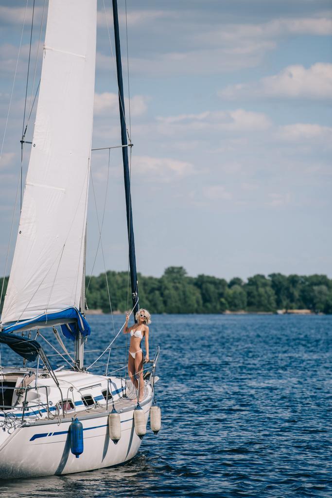bella giovane donna bionda in bikini in piedi su yacht
  - Foto, immagini