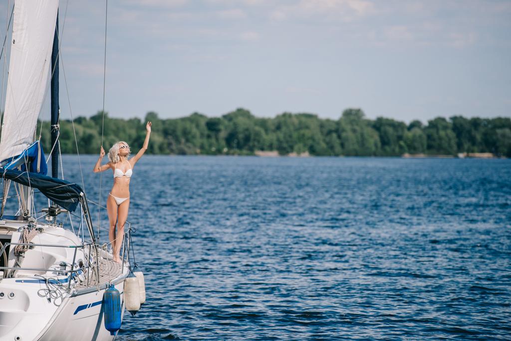 bella donna bionda in bikini in piedi su yacht
  - Foto, immagini