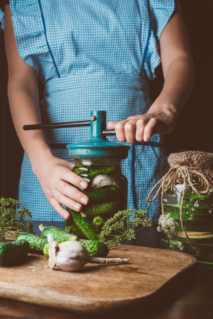 immagine ritagliata di donna che prepara cetrioli conservati a cucina
 - Foto, immagini