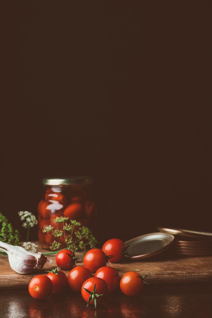 behouden van tomaten en verse tomaten op keukentafel - Foto, afbeelding