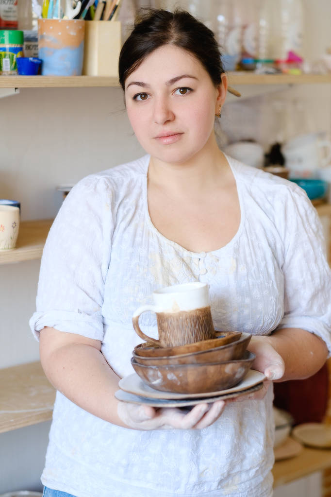 керамика бизнес-женщина держать изделия посуды тарелки
 - Фото, изображение