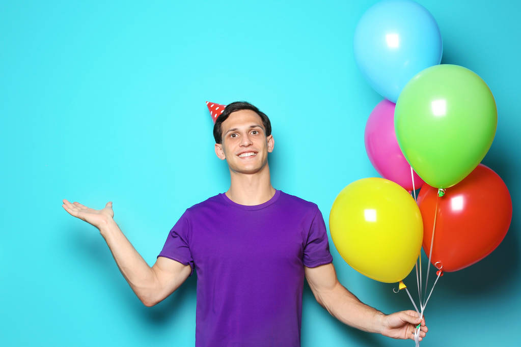 Parlak balonlar renk arka plan üzerinde olan genç adam. Doğum günü kutlaması - Fotoğraf, Görsel
