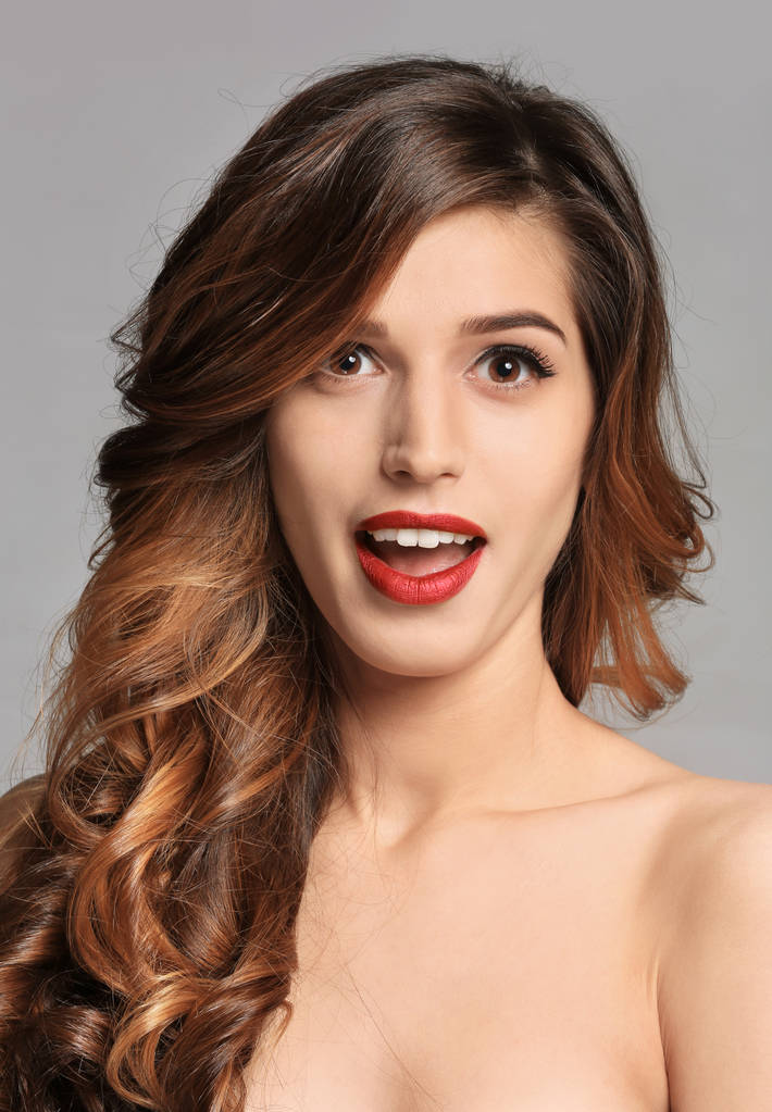 junge Frau mit elegantem Make-up und langen Wimpern auf grauem Hintergrund. Wimpernverlängerungen - Foto, Bild