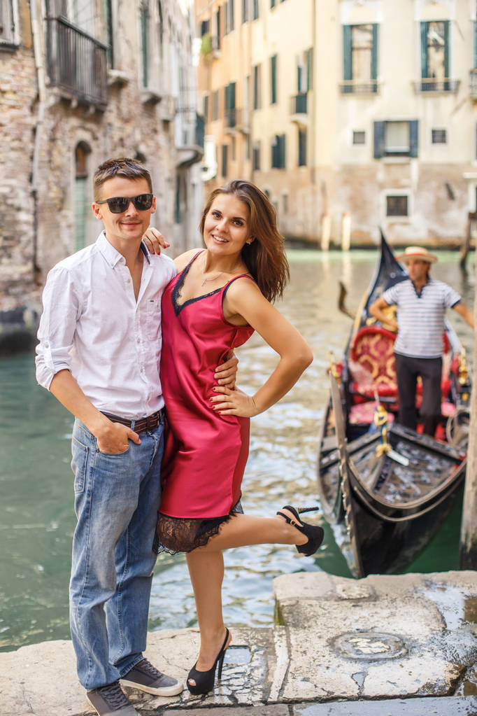 Jongeman omarmen zijn vriendin op de kade van kanaal in Venetië - Foto, afbeelding