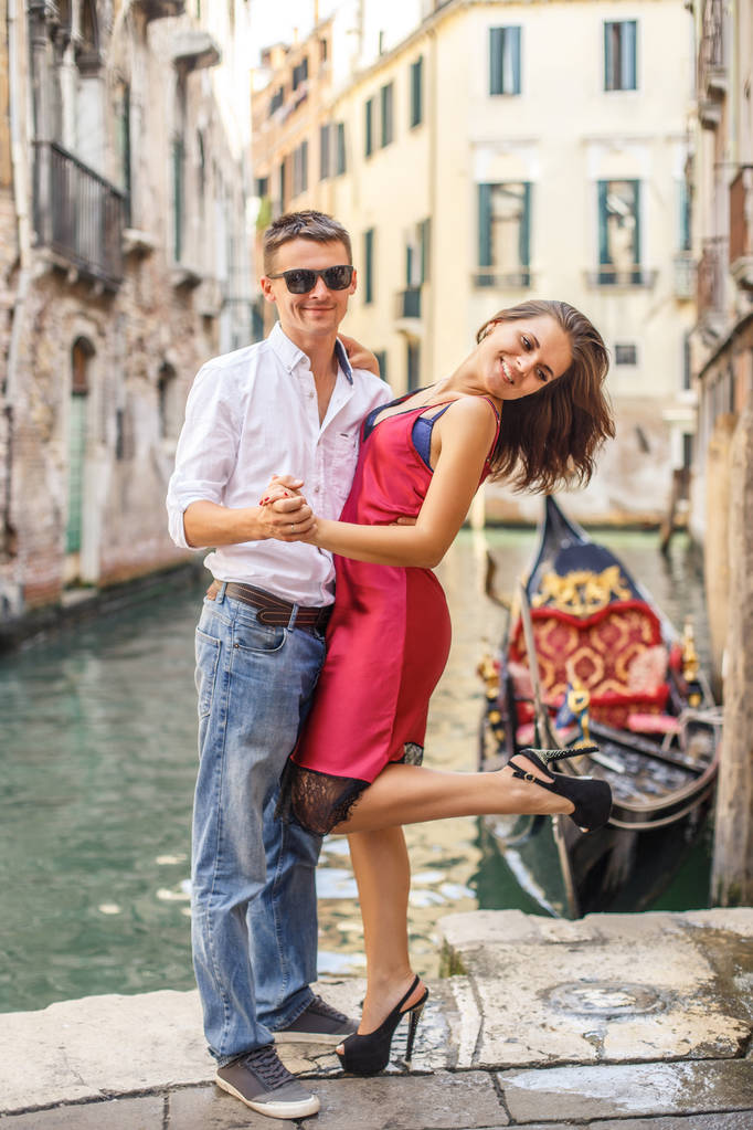 Jongeman omarmen zijn vriendin op de kade van kanaal in Venetië - Foto, afbeelding