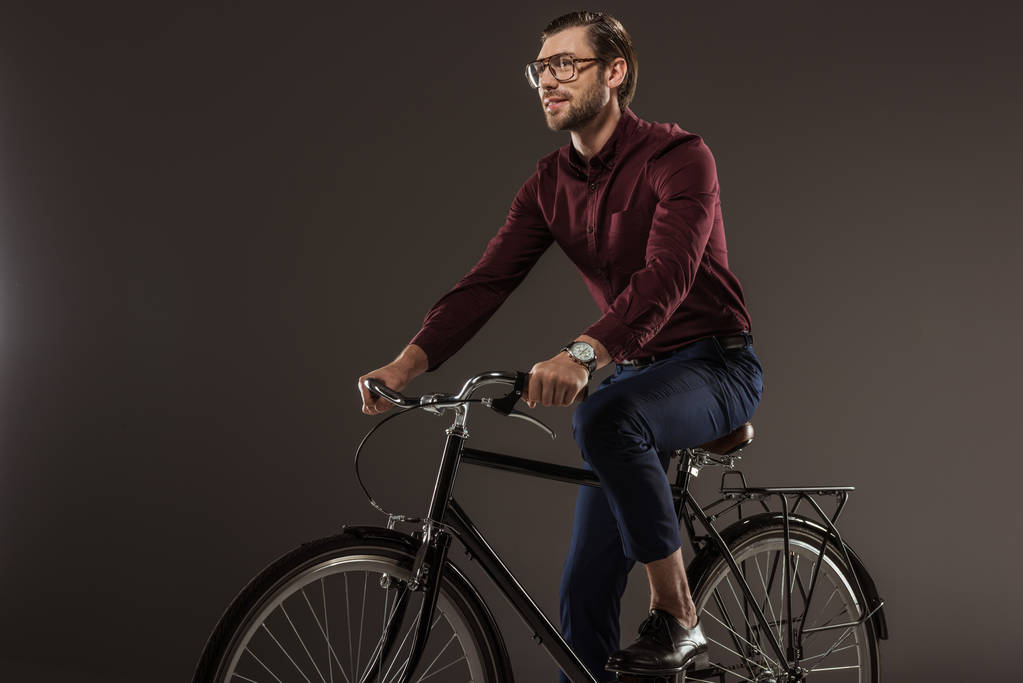 bonito jovem no óculos andar de bicicleta no preto
 - Foto, Imagem