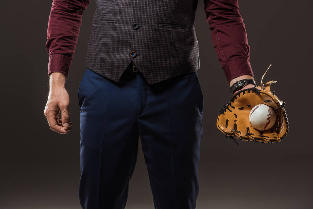 przycięte gorące biznesmena z rękawicy baseballowej trzymając piłkę na czarnym tle - Zdjęcie, obraz