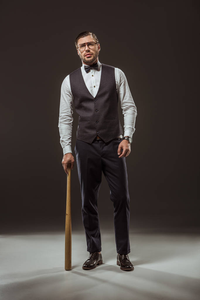 handsome stylish man standing with baseball bat on black - Photo, Image