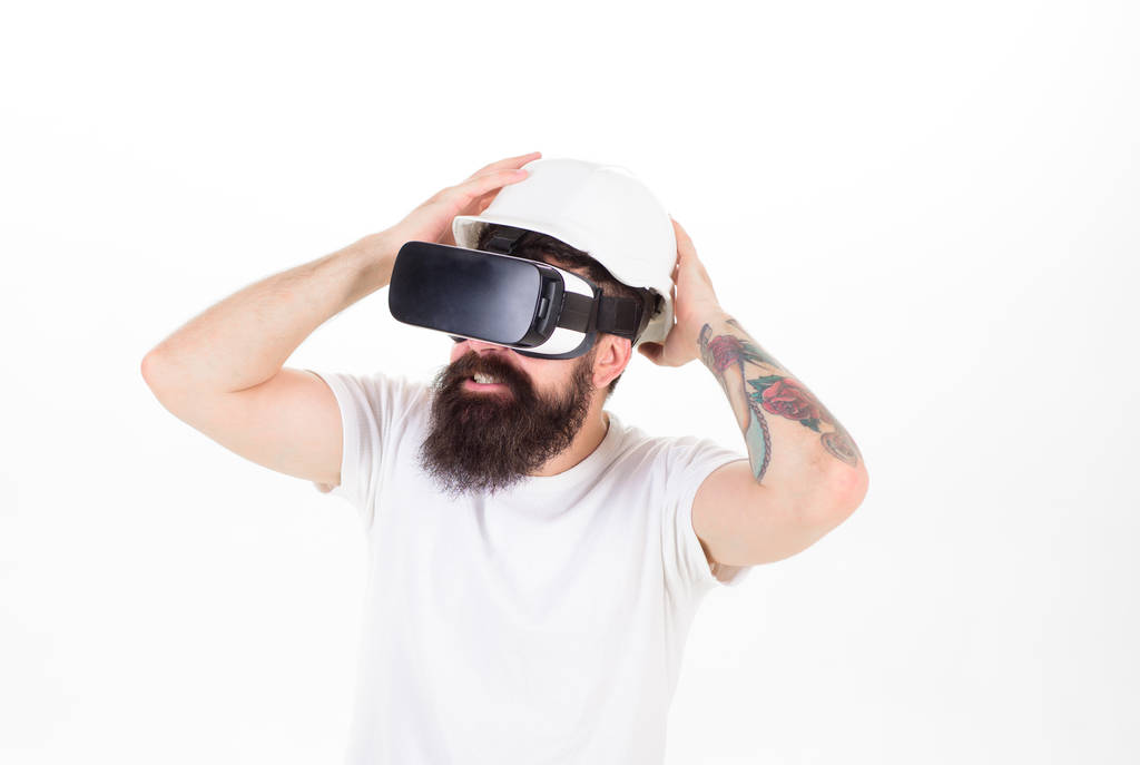 Бородатый мужчина в шлеме для защиты в компьютерной игре виртуальной реальности. Хипстер со стильной бородой тестирования нового гаджета на белом фоне. Игрок с бородой наслаждается трехмерным опытом, игровой концепцией
 - Фото, изображение