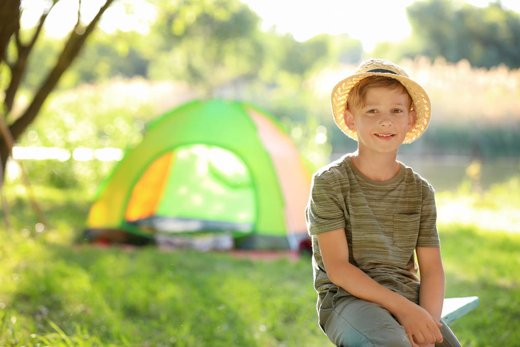 Pieni poika lähellä telttaa ulkona. Kesäleiri
 - Valokuva, kuva