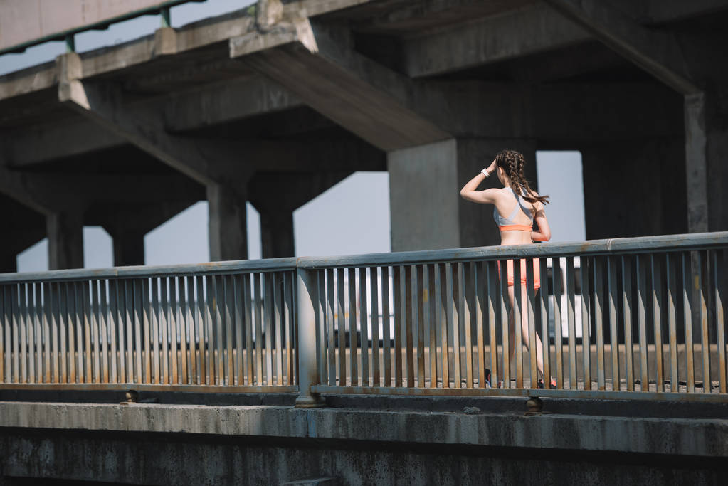 jonge jogger uitgevoerd op brug in de stad - Foto, afbeelding