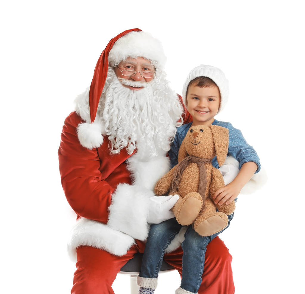 Petit garçon avec lapin jouet assis sur les genoux du Père Noël authentique sur fond blanc
 - Photo, image