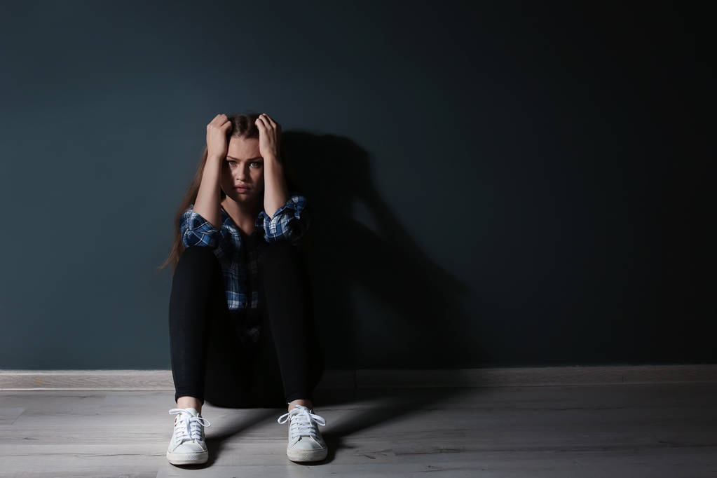 Κατάθλιψη νεαρή γυναίκα που κάθεται στο πάτωμα στο σκοτάδι - Φωτογραφία, εικόνα