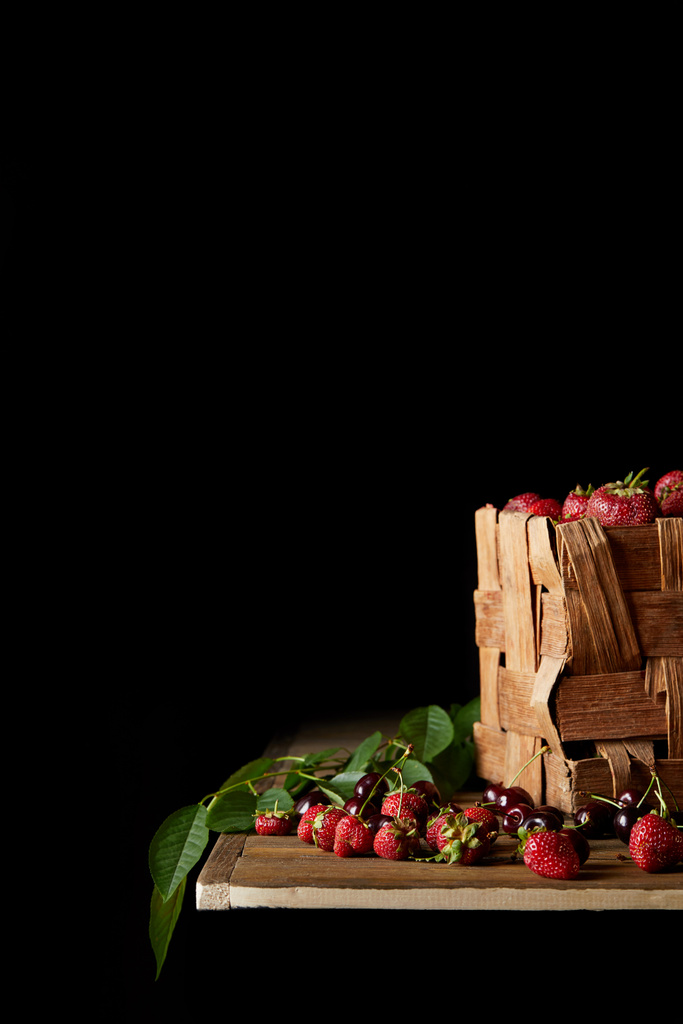 dojrzałych wiśni i truskawek na drewnianym stole i na czarno - Zdjęcie, obraz