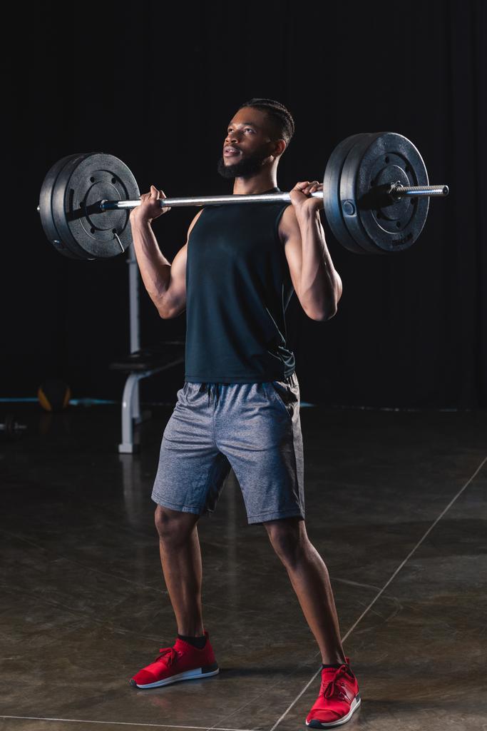 athletic african american man in sportswear lifting barbell in gym  - Photo, Image