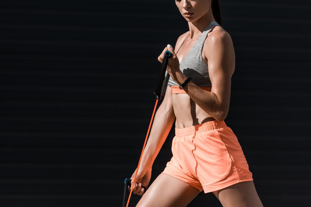 vista recortada de chica deportiva haciendo ejercicio con banda elástica
 - Foto, Imagen
