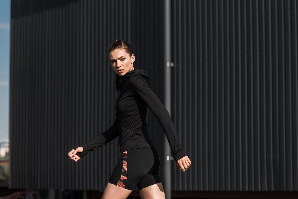 mooie jonge sportieve vrouw in zwarte thermische kleding - Foto, afbeelding