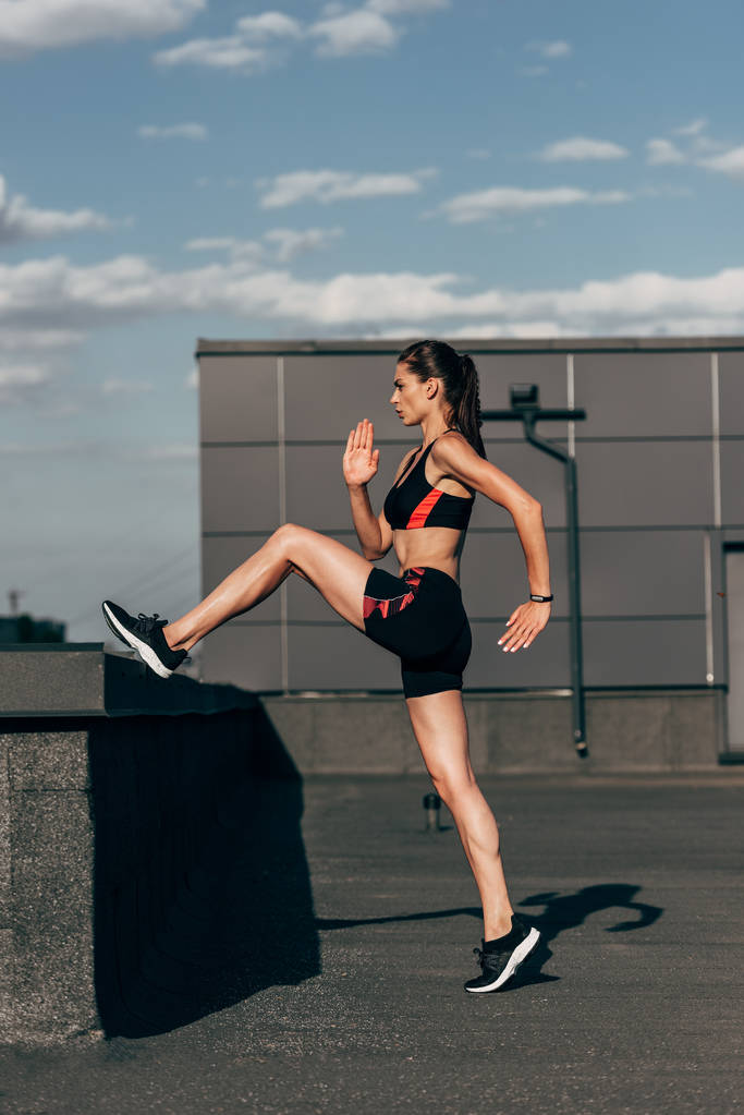 атлетичная девушка в спортивной одежде занимается кардиотренировкой на крыше
 - Фото, изображение