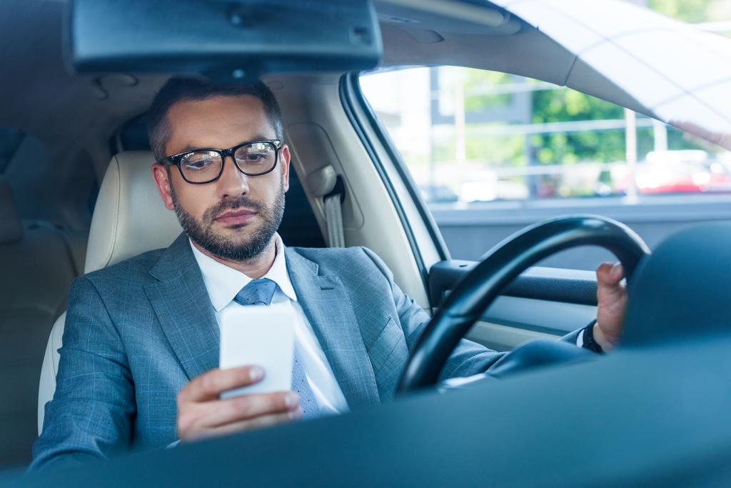 portrait d'un homme d'affaires en lunettes utilisant un smartphone en voiture
  - Photo, image