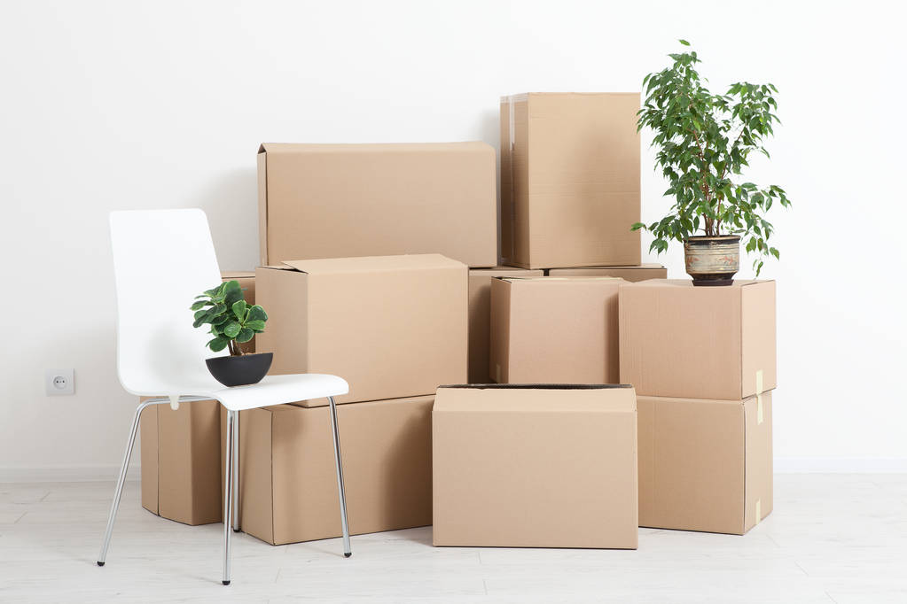 Moving into a new apartment. Move lots of cardboard boxes in an empty new apartment. - Photo, Image
