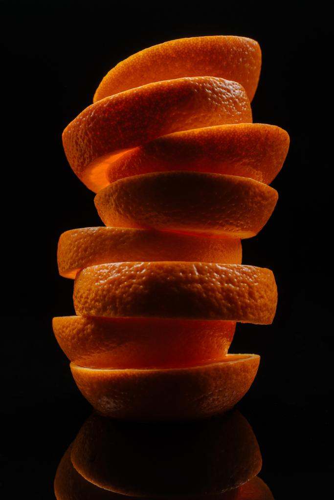 gros plan de tranches empilées d'orange fraîche isolées sur noir
 - Photo, image