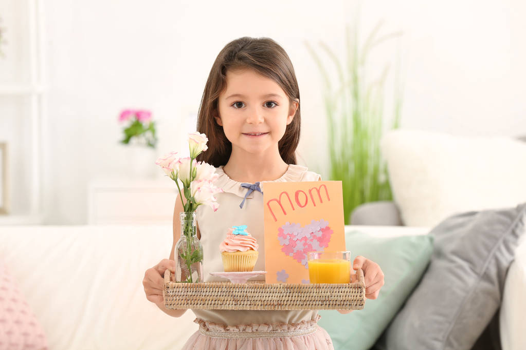 Little girl holding tray with breakfast and greeting card for her mommy on Mother's Day indoors - Photo, Image