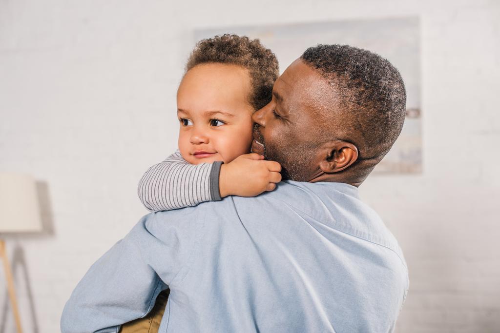 feliz africano americano abuelo abrazando adorable poco nieto en casa
  - Foto, Imagen