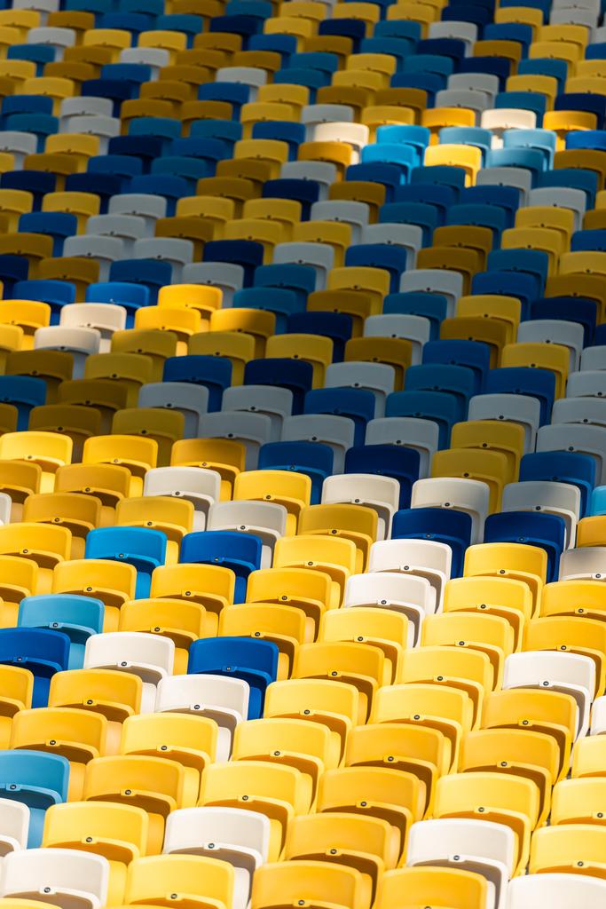 marco completo de tiro de asientos vacíos de colores en los tribunos del estadio
 - Foto, Imagen