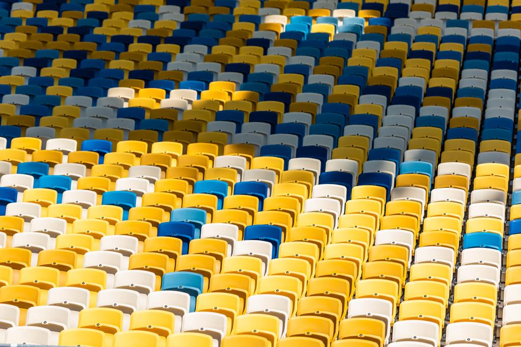 повнокадровий знімок порожніх барвистих сидінь на трибунах сучасного стадіону
 - Фото, зображення