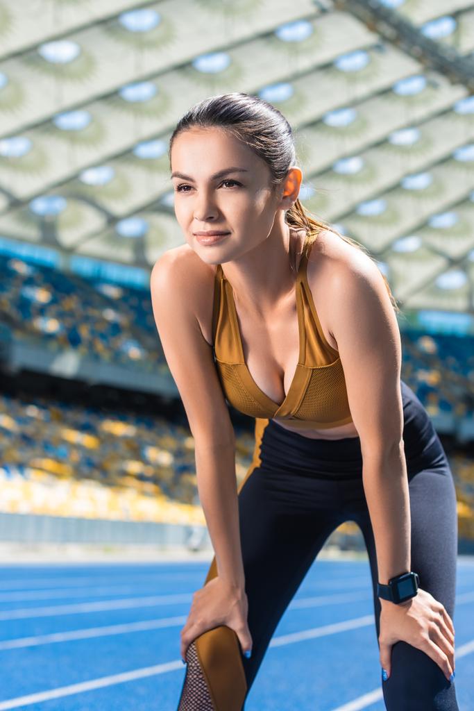 en forma joven mujer descansando después de trotar en pista de atletismo en el estadio deportivo
 - Foto, Imagen