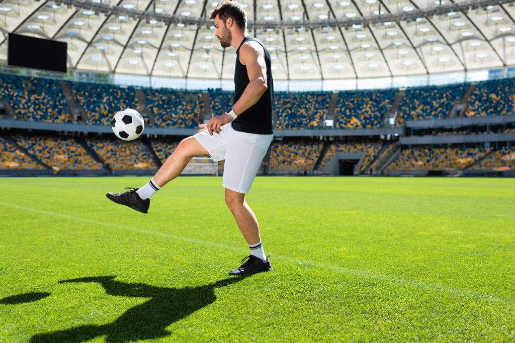σπορ νεαρό ποδοσφαιριστή αναπηδώντας την μπάλα στο πόδι στο αθλητικό στάδιο - Φωτογραφία, εικόνα