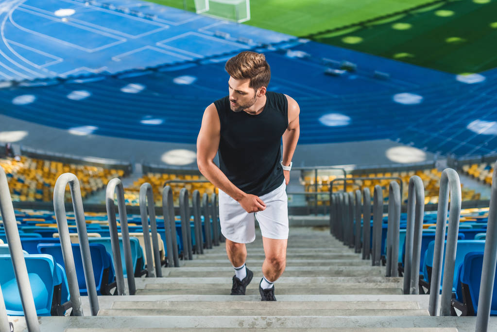 high angle view of sportive young man jogging upstairs at sports stadium - Photo, Image