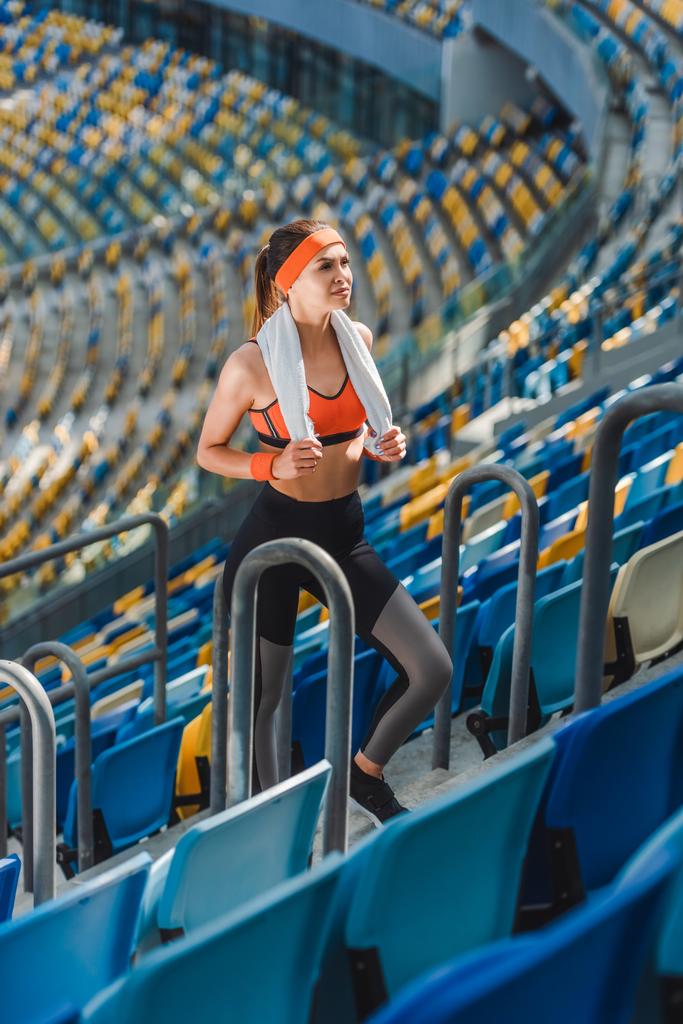 Blickwinkel auf attraktive junge Frau mit Handtuch im Sportstadion - Foto, Bild