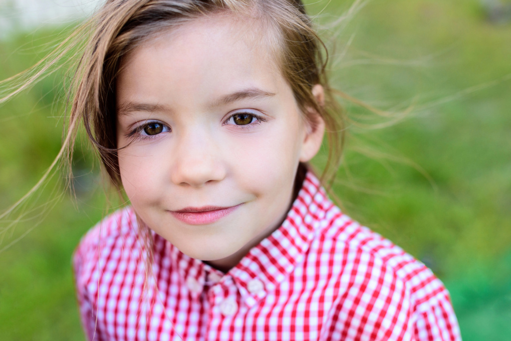 portret uśmiechający się małe dziecko na niewyraźne tło z bliska - Zdjęcie, obraz