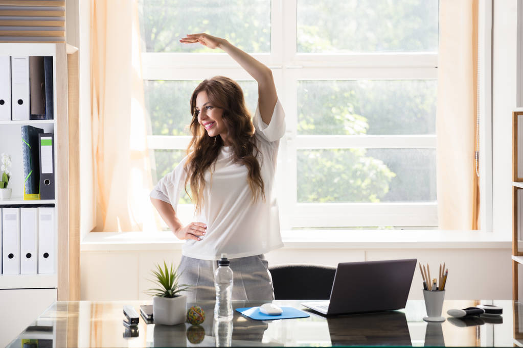glückliche junge Geschäftsfrau breitet ihre Arme im Büro aus - Foto, Bild