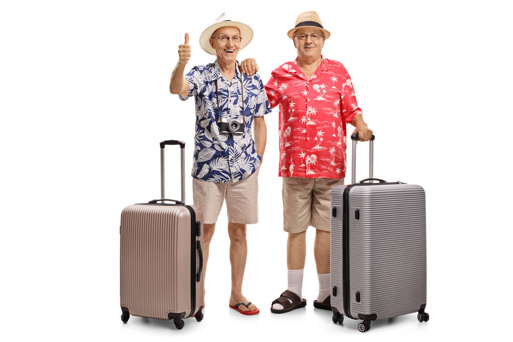 Beyaz arka plan üzerinde izole bavulları onlardan biriyle iki yaşlı turist portresi tam uzunlukta parmağını gidiyor - Fotoğraf, Görsel