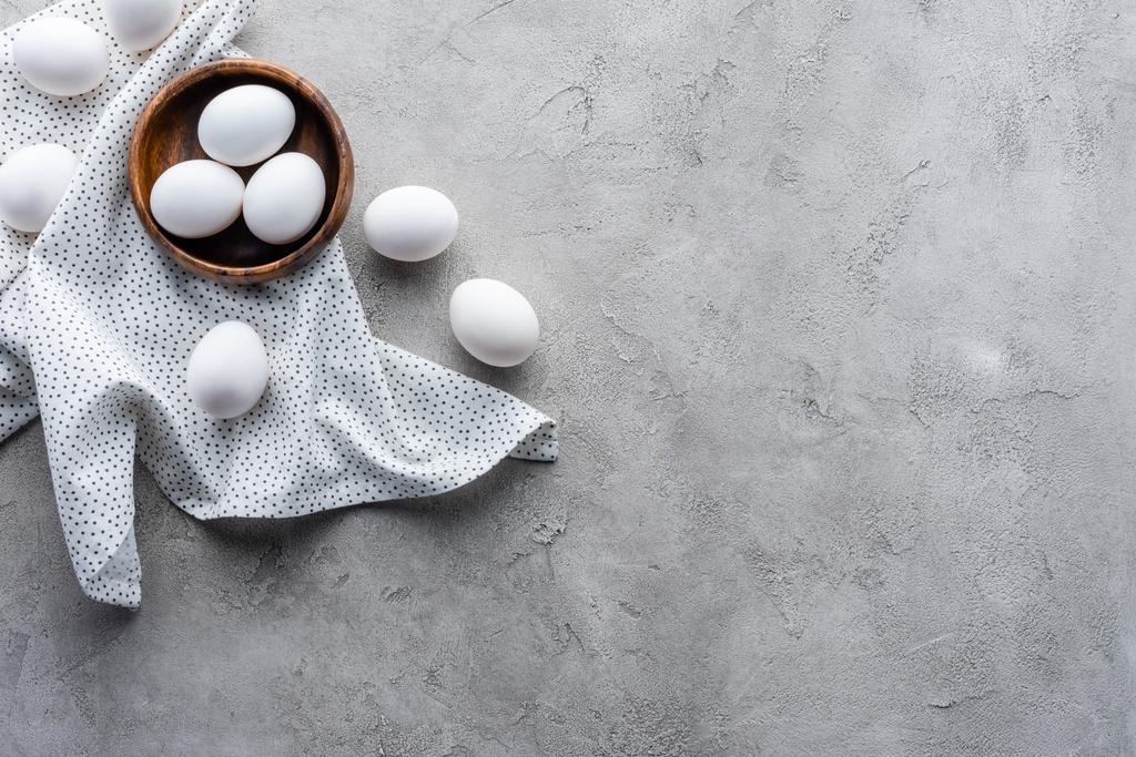 düz lay kase ve keten gri masa üzerinde çiğ tavuk yumurtası ile - Fotoğraf, Görsel