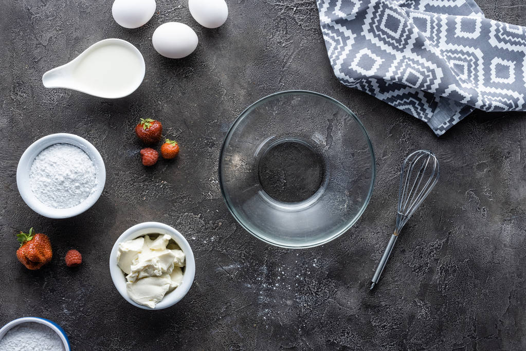 flat lay with arrangement of ingredients for homemade pie and empty bowl on dark grey surface - Photo, Image