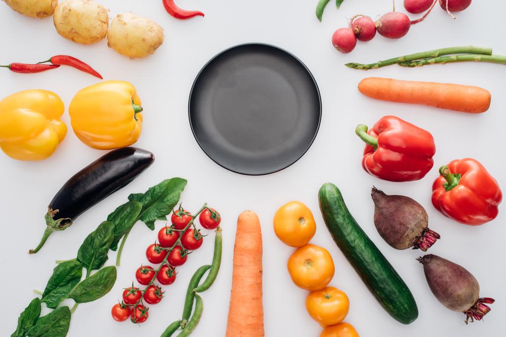 vista superior del plato redondo vacío y verduras frescas y saludables aisladas en blanco
   - Foto, imagen